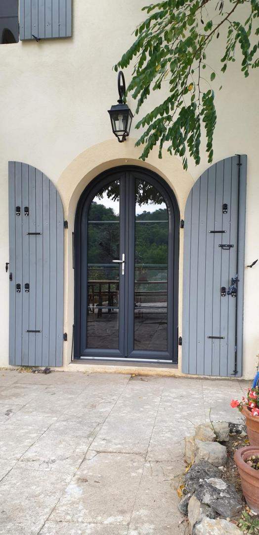 Porte-fenêtre PVC cintrée avec volets bleu-gris, Les Arcs